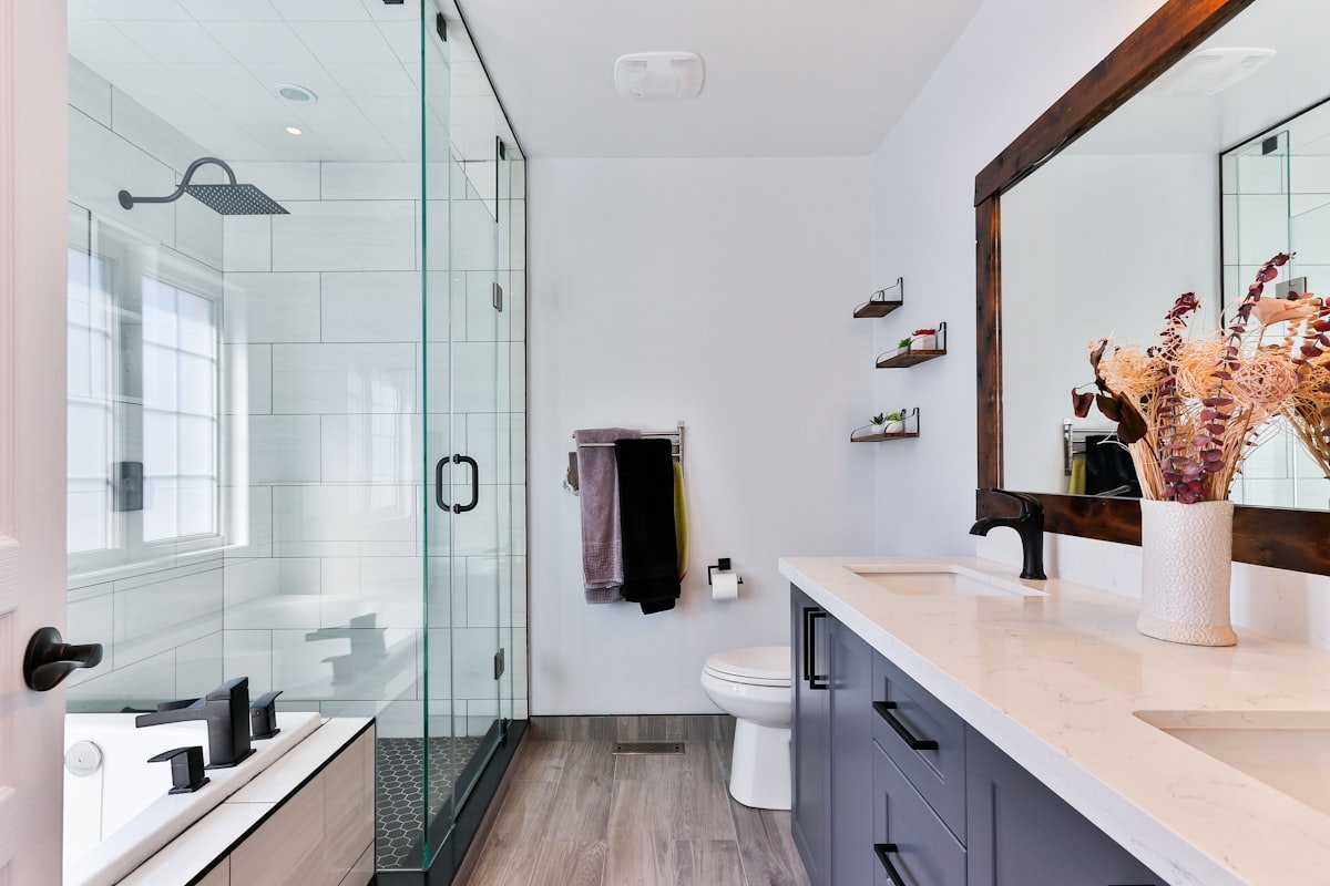 A clean well-designed feng shui bathroom with closed door and toilet lid down, showing proper drainage management and neutral earth tone colors